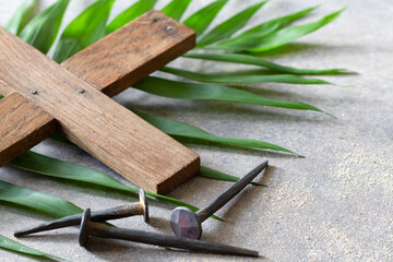 Wooden cross and old nails on palm branch. Palm Sunday religious concept