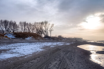 View of the sand beach with the tire marks and footprints on the Baltic Sea coast on the Vistula...