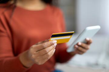 Mobile Payments. Black Woman Using Smartphone And Credit Card At Home