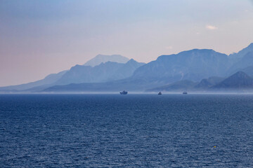 View of mountains and ships in a blue haze off the Mediterranean coast. Antalya, Turkey.