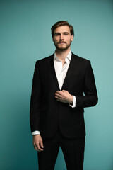 Portrait of handsome caucasian man in formal suit looking at camera smiling isolated on blue background