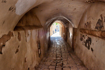 Ancient arched passage on a narrow paved historical street in Old Jaffa, Tel Aviv, Israel.