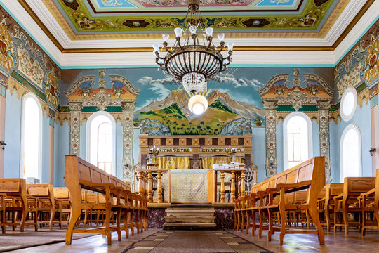 Kutaisi Synagogue inside view of nave and altar with wooden benches and richly decorated walls with colorful paintings, Georgia