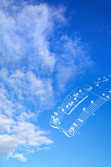 美しい青い空と白い雲と楽譜の合成