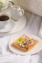 Morning breakfast with buns with cream, berries, fruits on a white tray. Breakfast in bed.