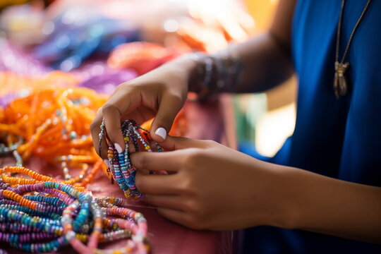 Close up view of hands of african american woman making handmade traditional jewelry bracelets from beads and pearls