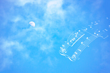 美しい青い空と白い雲と昼間の月と楽譜の合成