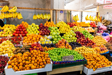 Market stall with colorful local fruits in Kutaisi Central Market (Green Bazaar,  Mtsvane Bazari)...