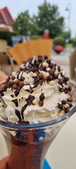 Close-up view of a chocolate sundae topped with whipped cream and chocolate balls
