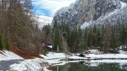 chalet au bord d'un lac gelé au début de l'hiver