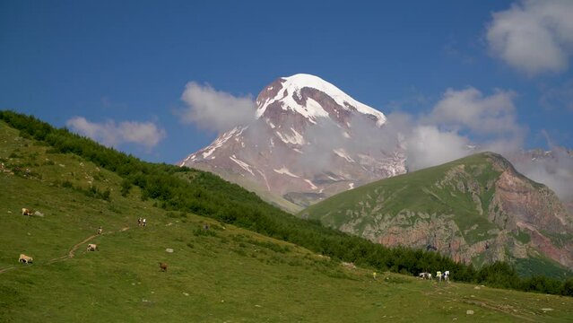 View of the peak of Kazbek looking out from behind the mountains on a clear day