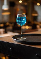Glass of blue lagoon cocktail on bar counter