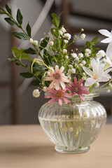 Spring white and pink flowers in a bouquet in a glass vase
