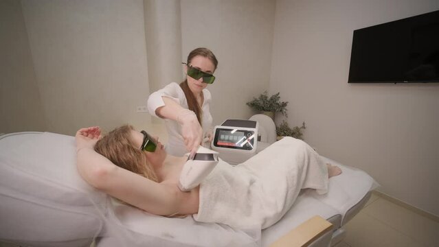 Woman armpit area during procedure of laser hair removal in modern cosmetology clinic. Concept of women beauty, cosmetology, epilation