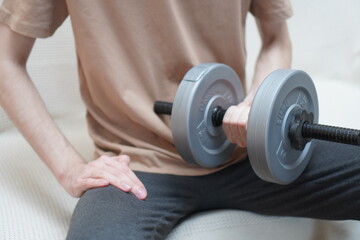 close-up of men's hands with dumbbells made of plastic for sports and muscle building of a European...