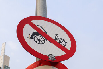 a traffic sign indicating that rickshaw or tricycles are prohibited from crossing the road....
