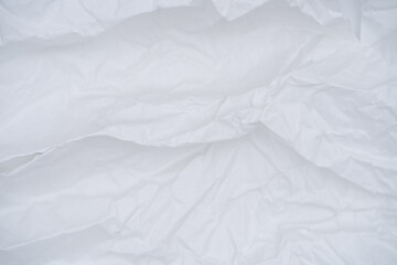 Softly crumpled white paper texture with subtle folds and creases, great for creative backgrounds and overlays.