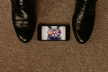 Men classic fashion formal shoes style wedding rings lie in picture of cat with glasses on phone