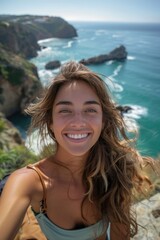 A joyful and sun-kissed woman takes a selfie, beaming at the camera against a stunning sea backdrop