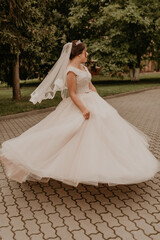 Caucasian young woman bride spinning whirls dancing posing moving at nature