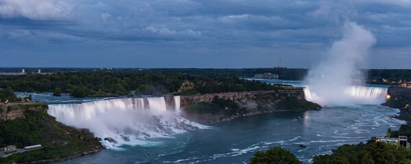 Elevated view of brightly illuminated American and Horseshoe falls at dusk, Niagara Falls, Canada