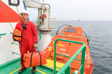 Seaman wearing lifejacket with vhf radio on Muster station. Abandon ship drill. Free fall boat....