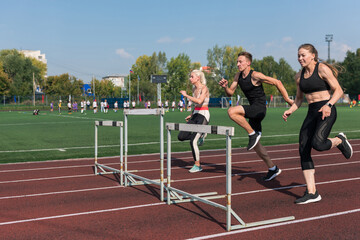 Two athlete woman and man runnner running hurdles