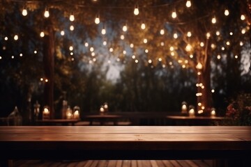 Wood table top with outdoor string lights hanging on tree in garden at night, fairy lights