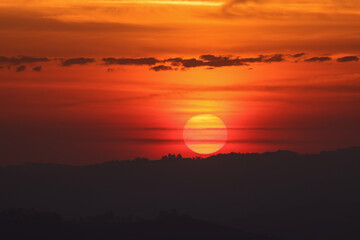 the sun rises behind a mountain range in Piedmont