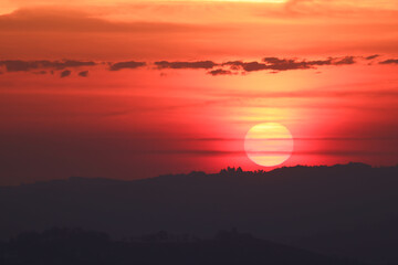the sun rises behind a mountain range in Piedmont