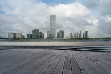 empty ground floor with modern cityscape and cloudy sky.