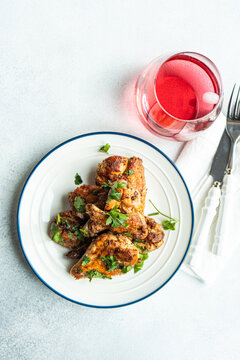 Overhead view of Roasted chicken wings with coriander and a fruit drink