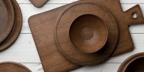 Collection of rustic empty wooden cutting or chopping boards, wooden plates and bowls on white wooden plates table background flat lay top view from above