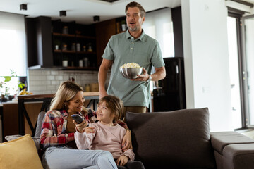 Family Movie Night: Engrossed in Thrilling Scenes at Home
