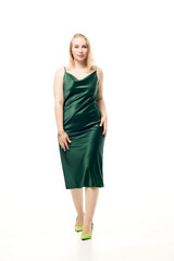 Young blonde woman in a green slip dress on a white background.