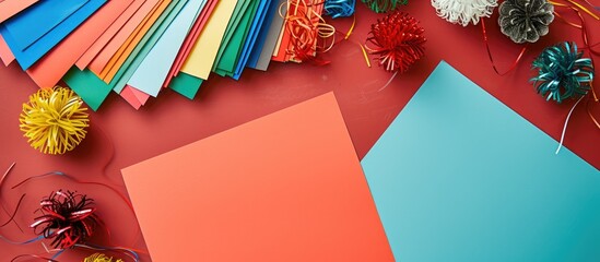 A variety of different colored paper sheets are scattered across a table. Each sheet is square-shaped, ready to be used for a DIY winter craft project.