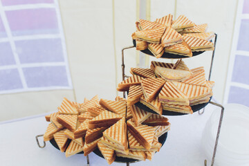 Cut platter of mixed sandwich triangles catering.