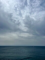 Naklejka na ściany i meble Cloudy seascape, sail boats silhouettes at the sea