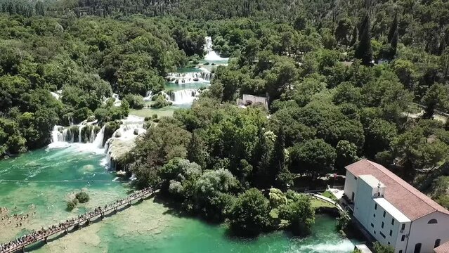 Aerial shot of a beautiful waterfall between trees on a sunny day, above Karka Falls, Croatia