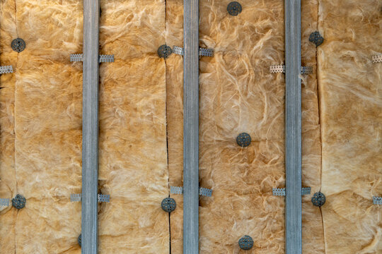 Metal ceiling framework with soundproofing, fixed to concrete using anchors, showcases assembly technology for acoustically insulated spaces.