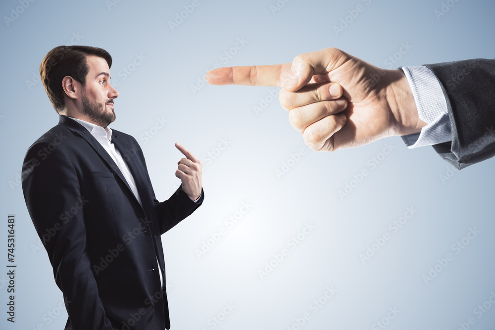 Poster abstract image of boss hand pointing at businessman on light gray background. bad job decision and m