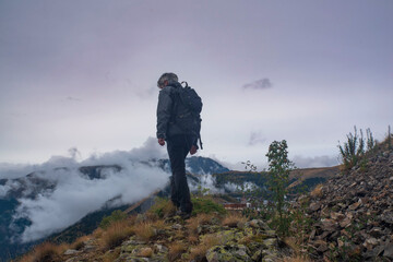 Hiker in a mountain landscape in summer with the glaciers of the Ecris massif in the background