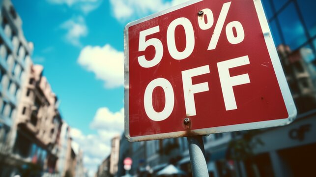 a red sign with the words 50 % off under a blue sky with clouds in the background