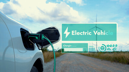 Electric car recharging energy from EV charging station display futuristic smart battery status hologram by EV charger plug cable in wind turbine farm. Alternative clean energy sustainability. Peruse