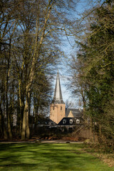 Reformed church or Maartenskerk from grounds of huis Doorn manor house, Netherlands on sunny day. Religious Dutch historic building place of worship in community originally known as St. Maarten