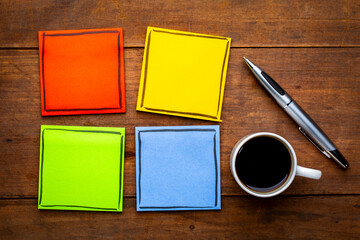 set of colorful, blank reminder notes on a grunge wooden table with a cup of espresso coffee and pen