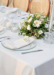 Wedding table decoration with fresh colorful flowers, plates and candles