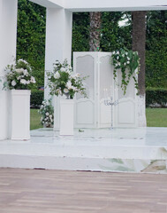 wedding dais. Wedding ceremony area. White wooden boxes on a green lawn. Wedding festal arch. 