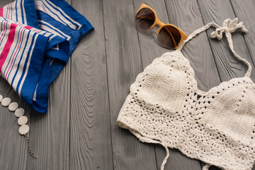 white knitted top woman trending two-piece swimsuit beach swimwear fashion sunglasses. Summer background