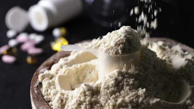 Pouring slow motion whey dry sport protein from above, supplements the food